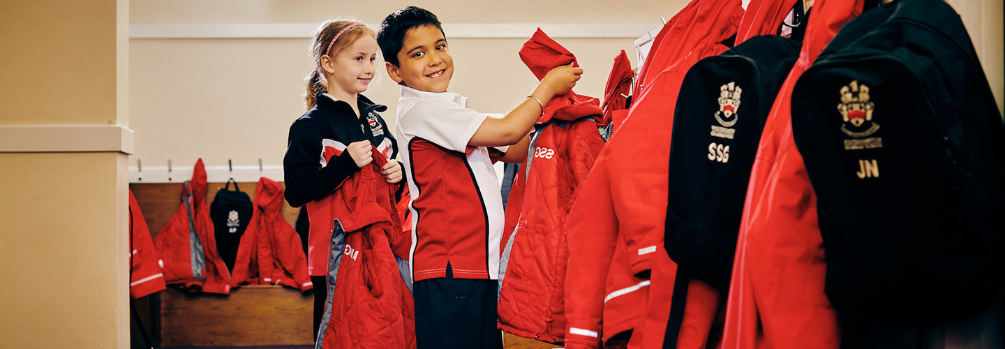 Junior School child hanging up coat